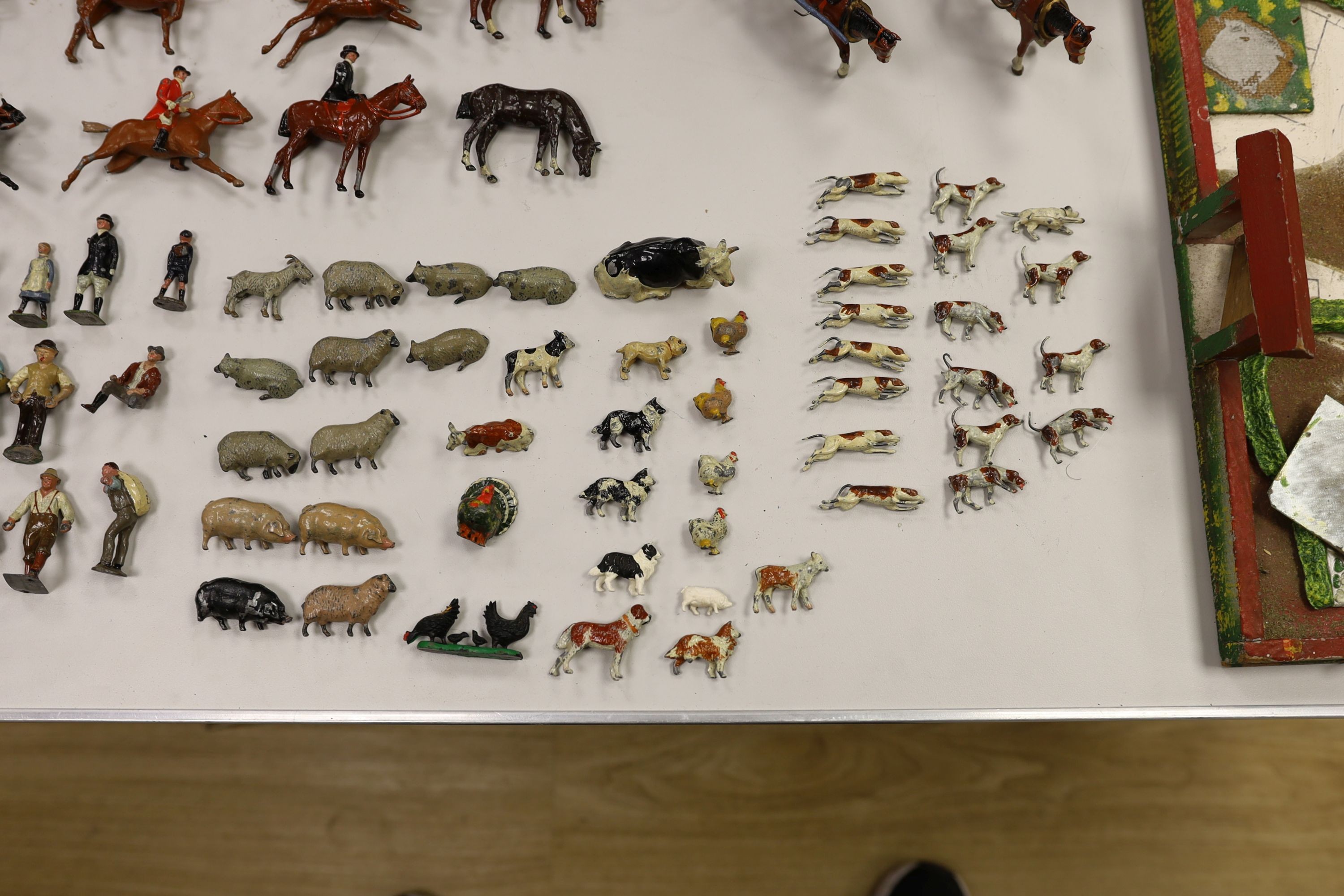 A collection of mainly Britains painted lead figures and animals, including huntsmen and hounds, farm workers, animals and wooden buildings